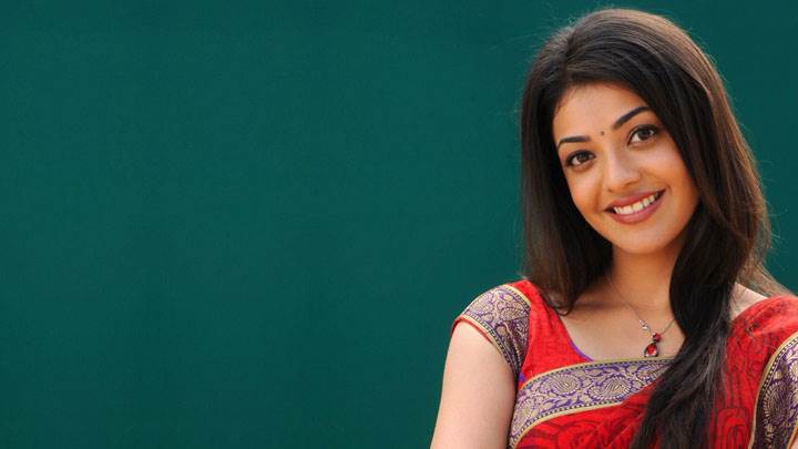 Kajal Aggarwal Smiling In Red Saree And Green Background